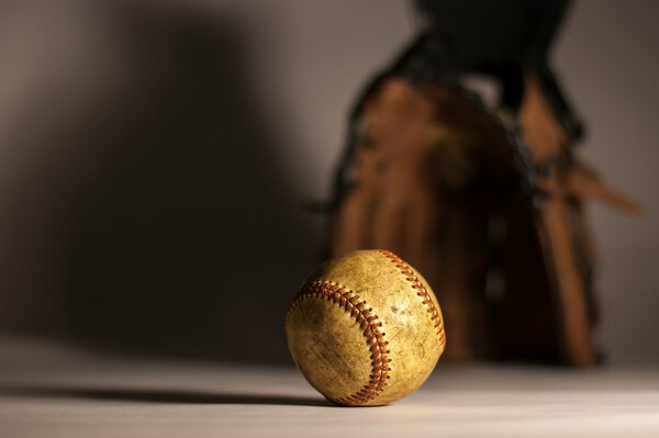 Baseball auf dem Tisch und Handschuh