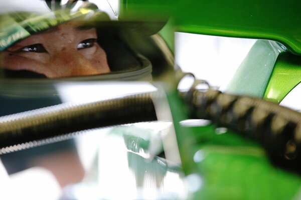 Pilota con casco verde in testa