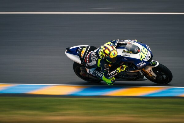 An athlete on a motorcycle develops speed