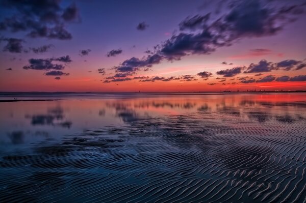 Der See ist mit einem rosa Sonnenuntergang bedeckt