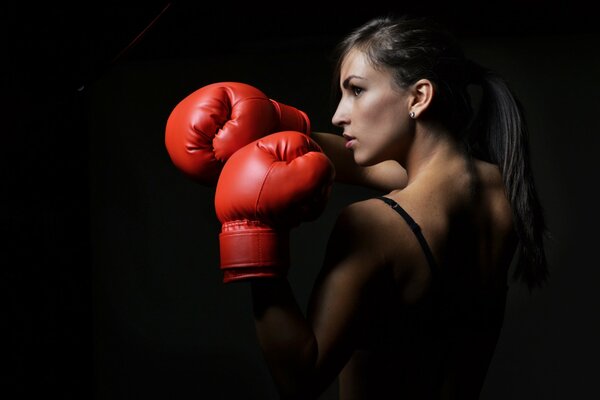 Guantoni da boxe rossi in una donna. Boxe. Posture difensive