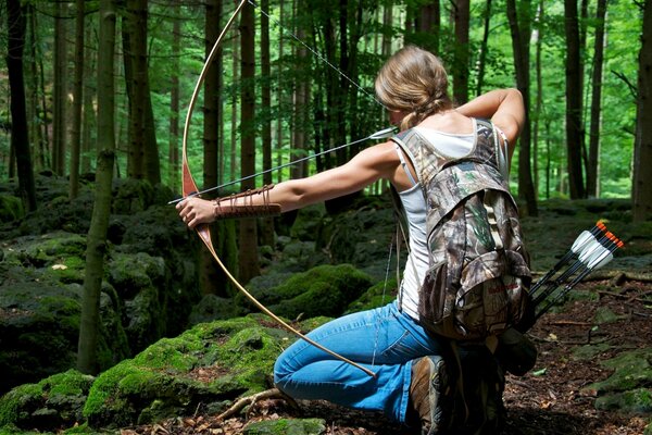 Mädchen mit Pfeil und Bogen im Wald. Bogenschießen