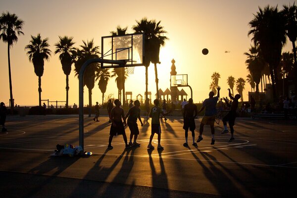 Menschen spielen Basketball am Strand