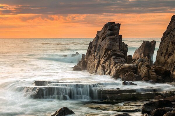 Rocce taglienti nel mare al tramonto