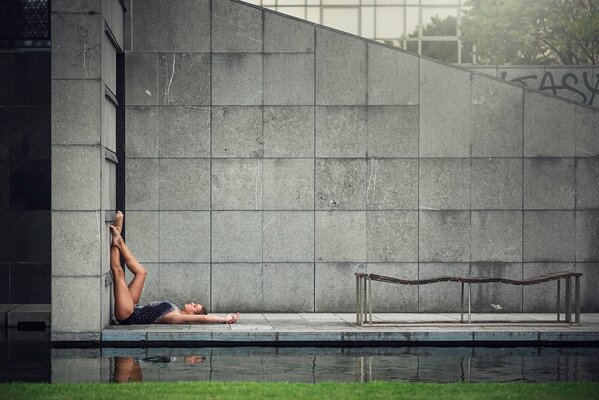 Graceful legs of a gymnast against a gray wall