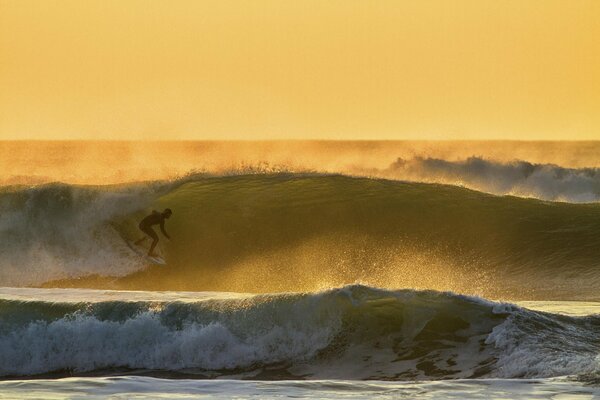 Atleta surfista esegue acrobazie in mare