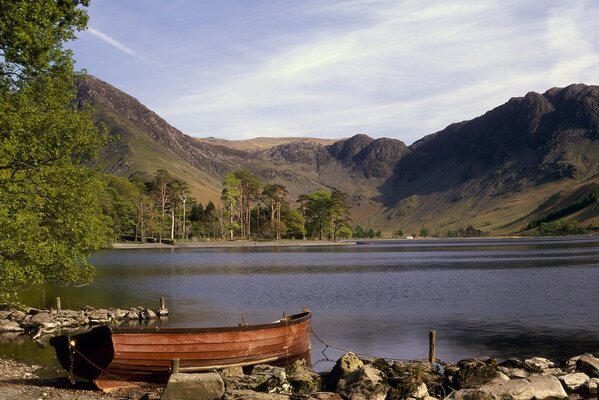 The boat is tied up on the shore of the lake