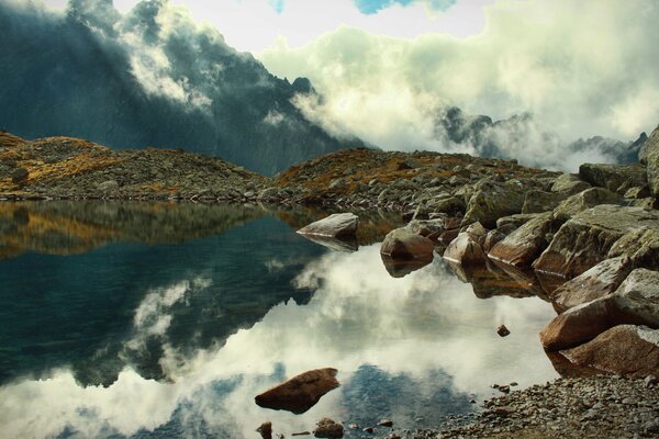 Flauschige Wolken im Nebel über den Felsen