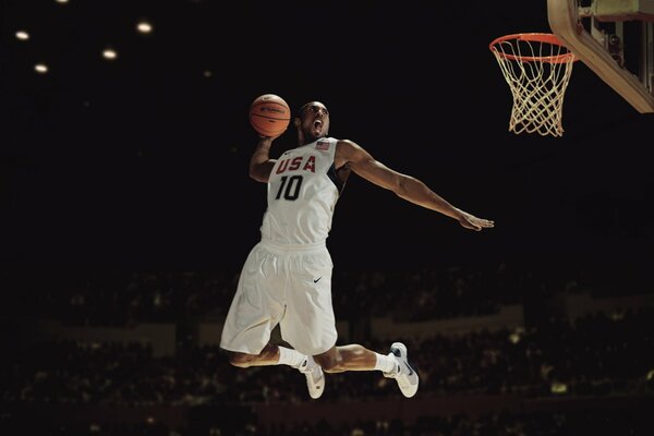 A basketball player throws the ball into the basket