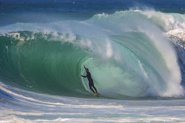 Surfer overcomes a wave of a tunnel on the ocean