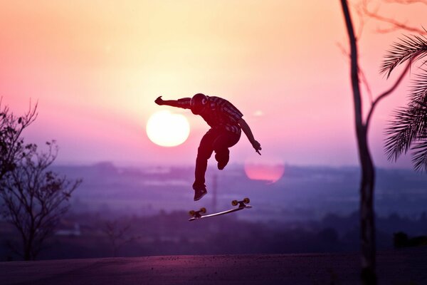 Skateboarder made a jump at sunset