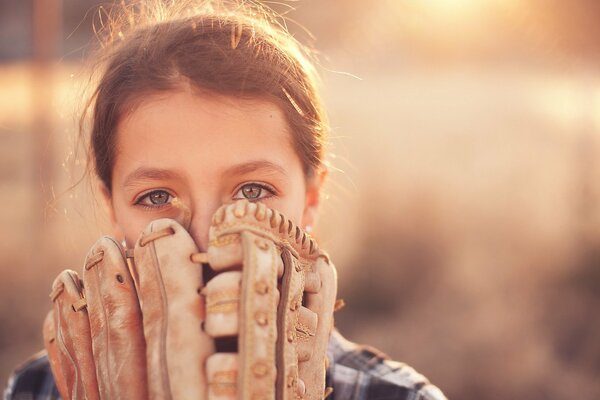 A girl with a glove playing baseball