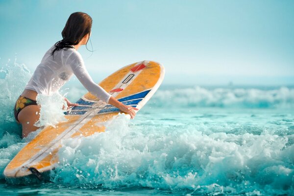 Girl on the waves on a surfboard