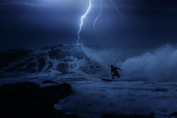 Il ragazzo fa surf, conquistando L onda di notte nell oceano con un temporale