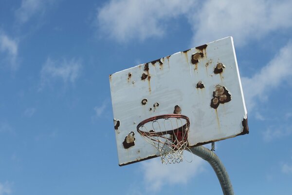 A rusty shield with a basketball hoop