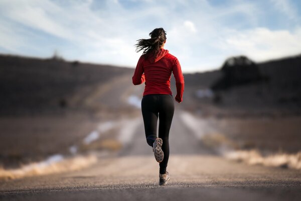 Athletic girl running on the road