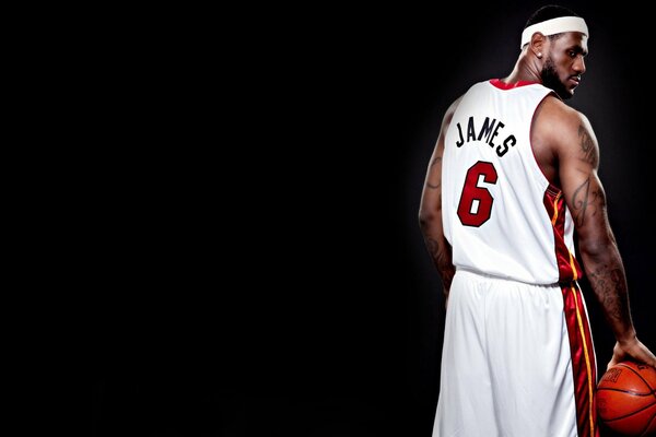 Foto del jugador de baloncesto James LeBron envuelto en un uniforme blanco sobre un fondo negro