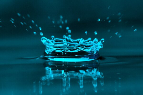 Macro photography of a drop that has fallen into the water and splashes from it