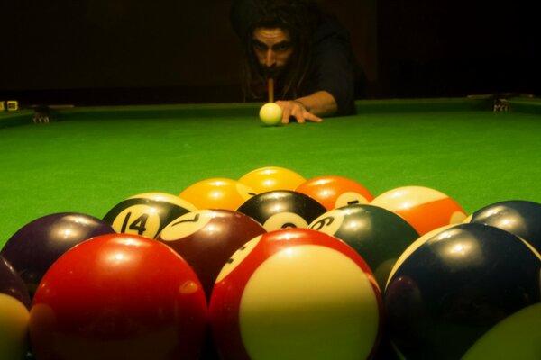 Homme jouant au billard boules colorées