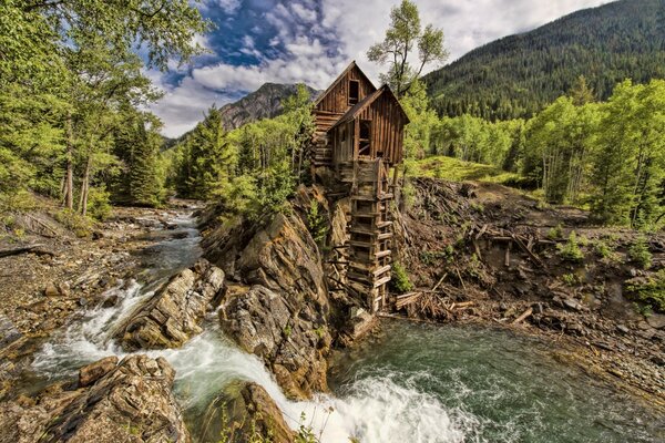 The house is located near a small waterfall and a river