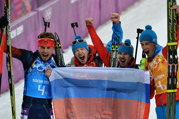 Los participantes del relevo de biatlón Anton shipulin, Alexei Volkov, Dmitry malyshko y Yevgeny Ustyugov, sosteniendo la bandera rusa, en los juegos Olímpicos de Sochi 2014