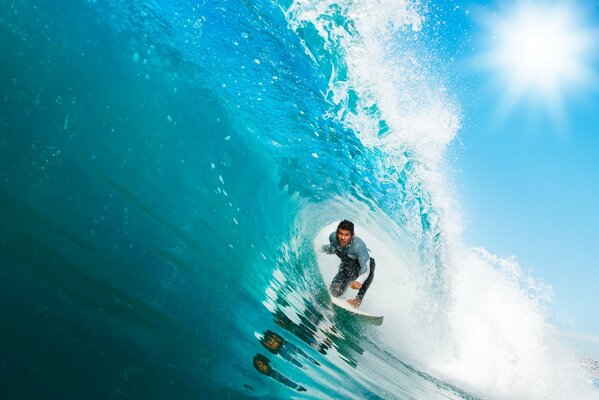 Surfen im Meer auf einem Brett, Surfen unter einem Wellenkamm durch den Surfer