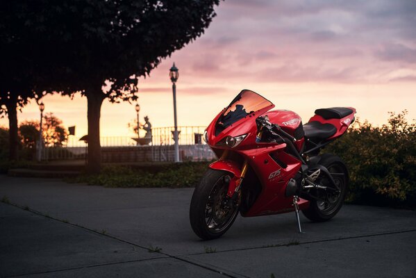 Moto deportiva roja en la carretera crepuscular