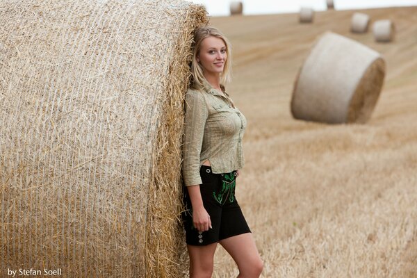 Fille blonde avec une botte de foin