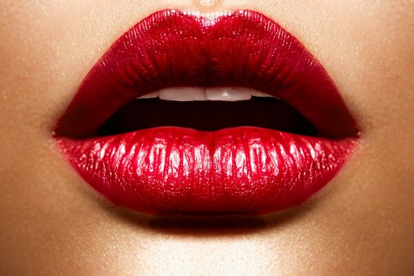 The red lips of a girl painted with lipstick hint at passion