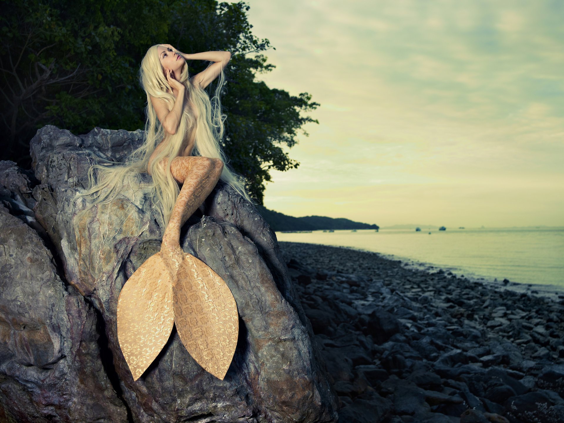 ragazza sirena coda bionda capelli lunghi sguardo trucco mare