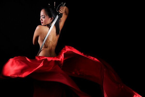 Fille en robe rouge danse avec l épée