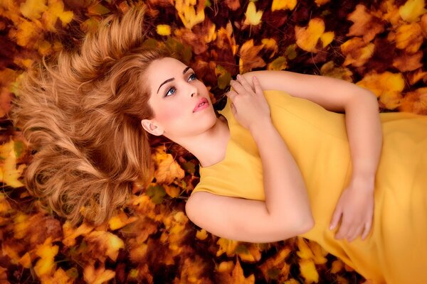 A red-haired girl in autumn foliage