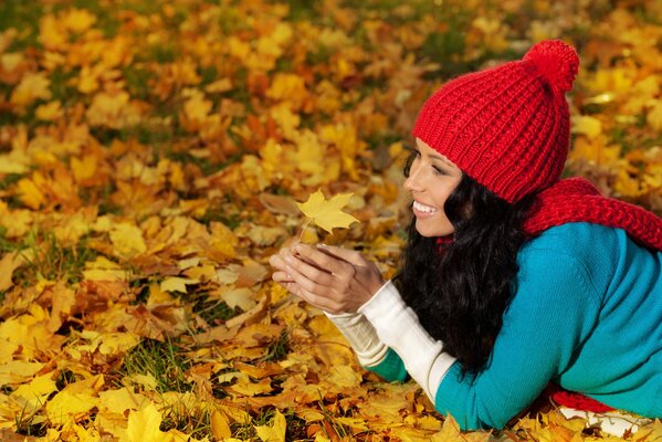 Servizio fotografico autunnale con ragazza in foglie