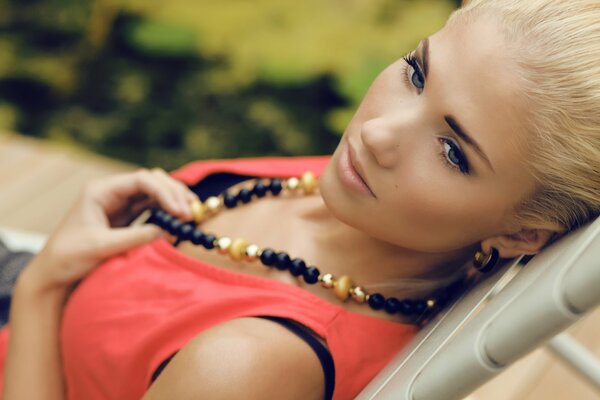 Blonde girl in beads with expressive eyes