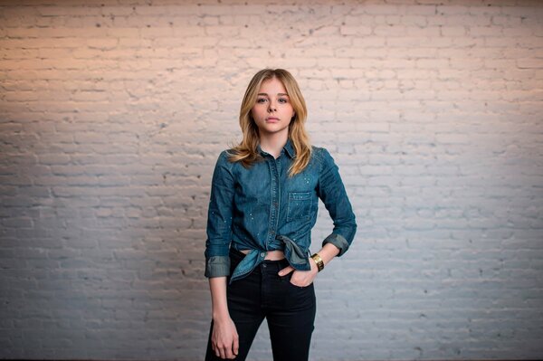 Chloe Grace Moretz on a white wall background