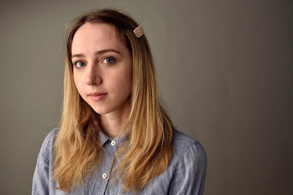 A girl in a blue T-shirt looks at the camera