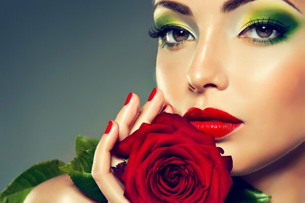 Ragazza con trucco verde-giallo e rosa in mano