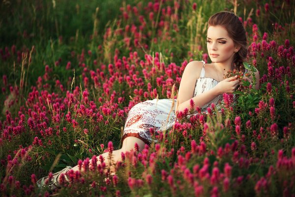 Chica de campo en la hierba con flores