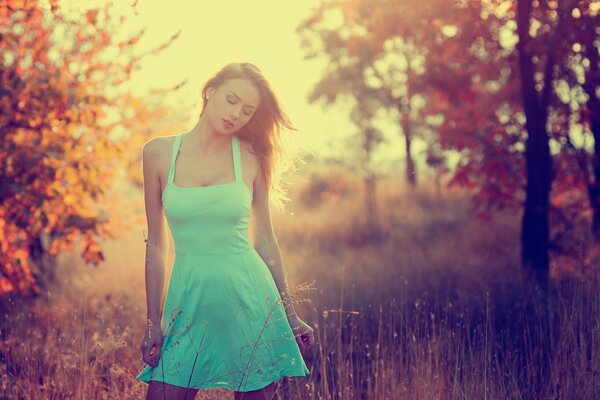 A girl in a blue short sundress in a field