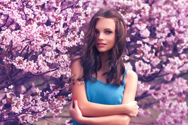 Fille souriante sur fond de fleurs de cerisier