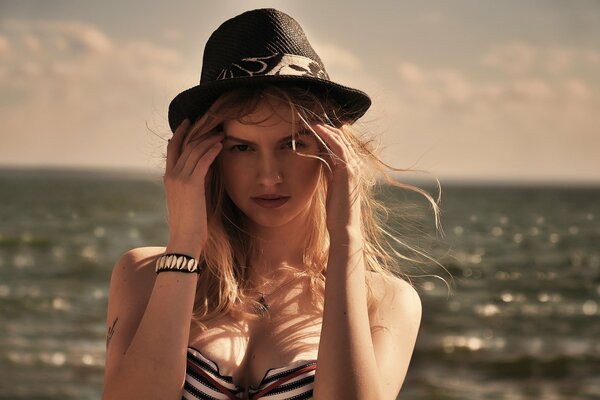 Fille avec chapeau sur fond de nuages et de la mer