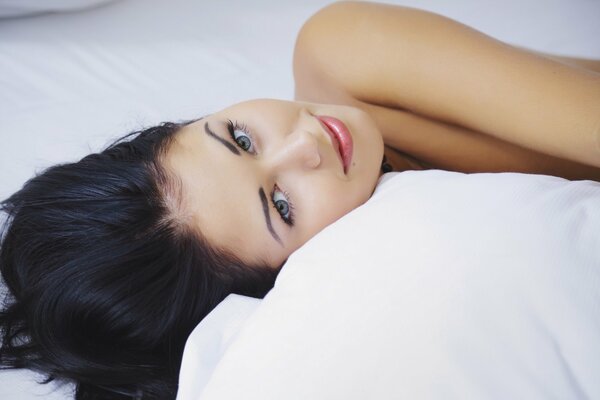 Ragazza con i capelli scuri si trova sul letto