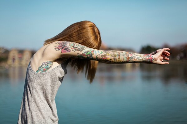 Mädchen mit Tattoo am ganzen Arm auf verschwommenem Hintergrund