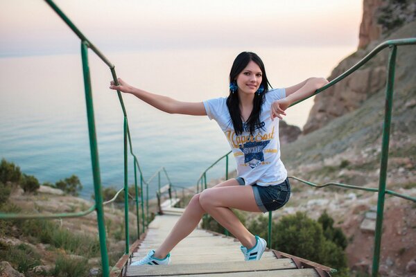 The girl holds on to the green railing