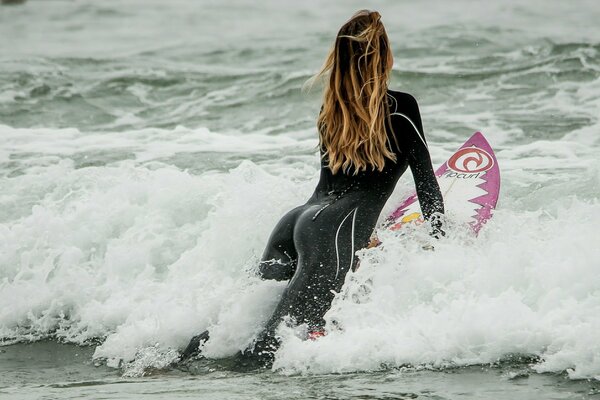 Dziewczyna na desce surfingowej w falach