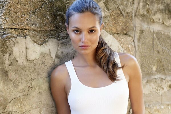 Bright look of a girl in a white T-shirt among the rocks