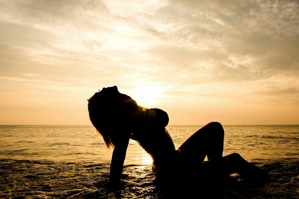 A girl in the sea against the sunset