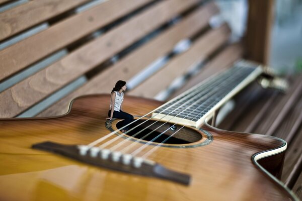 Mädchen sitzt auf der Gitarre