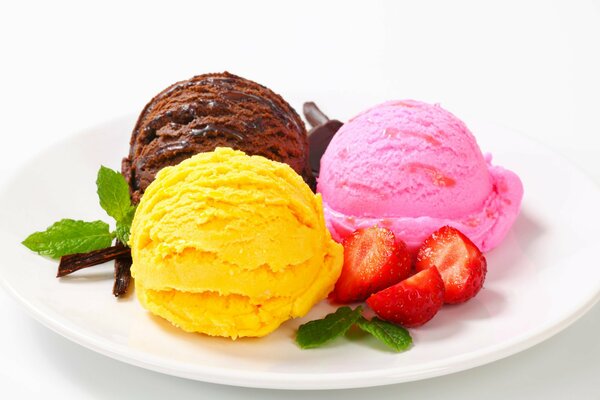 Bolas de helado de colores en un plato de fresas