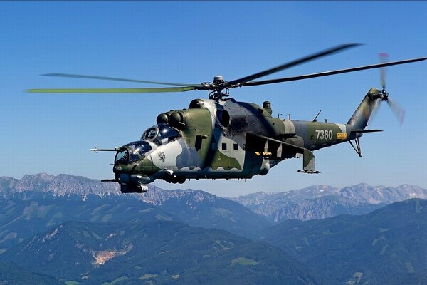 Trasporto e elicottero da combattimento sullo sfondo di montagne e cielo blu